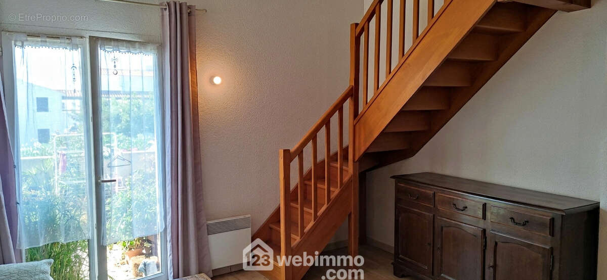 Pièce de vie avec escalier bois 1/4 tournant.