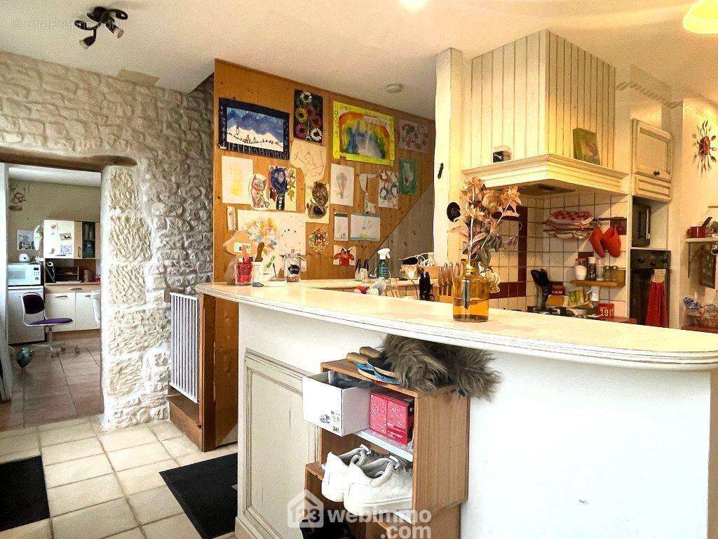 Derrière la cuisine, un dégagement dessert la buanderie, un WC, - Maison à NAINTRE