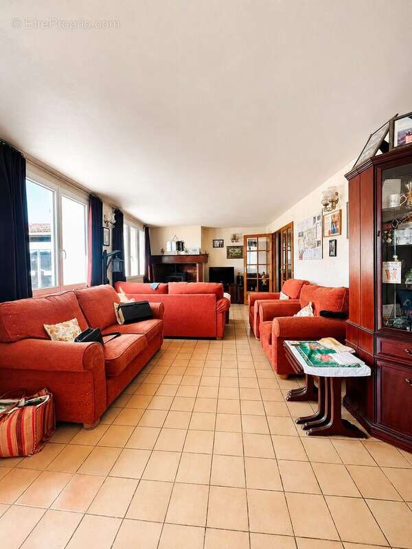 Living room with red sofas and wood-burning stove - Maison à MARCIAC