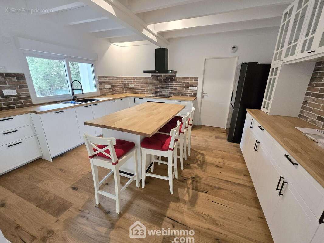 Une cuisine conviviale avec un grand îlot central - Maison à LE PIAN-MEDOC