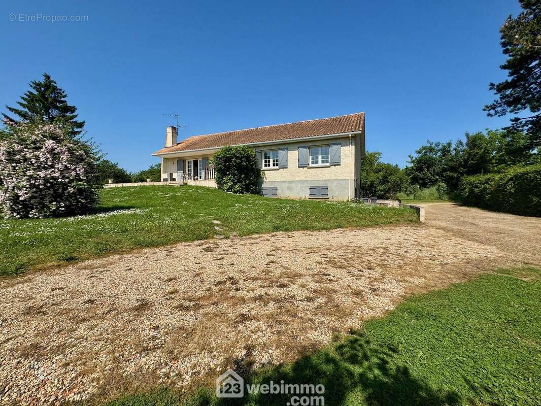 Au bout de l'allée, espace de stationnement, accès au garage et au préau. - Maison à MIGNE-AUXANCES
