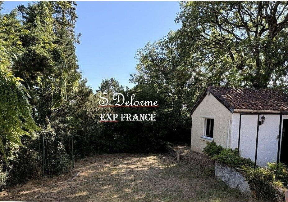 Vue de la porte fenêtre de la cuisine sur le jardin et le cabanon   