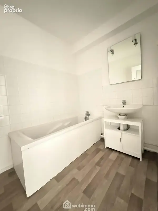 La salle de bains avec lavabo et baignoire