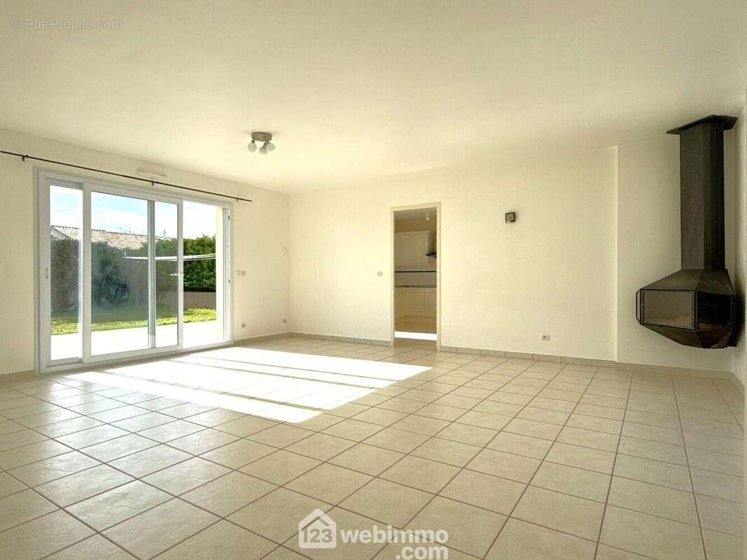 La pièce de vie de 34 m2, équipée d'un poêle à bois, - Maison à QUINCAY