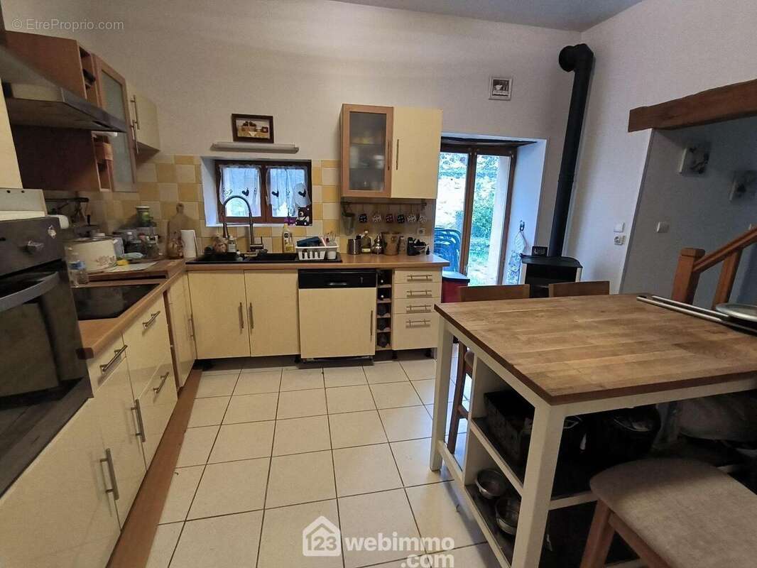 Une cuisine de 15 m² entièrement équipée avec un accès sur la terrasse - Maison à MONT-NOTRE-DAME