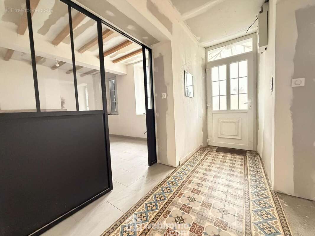 Une vaste entrée avec beaucoup de charme distribue ...