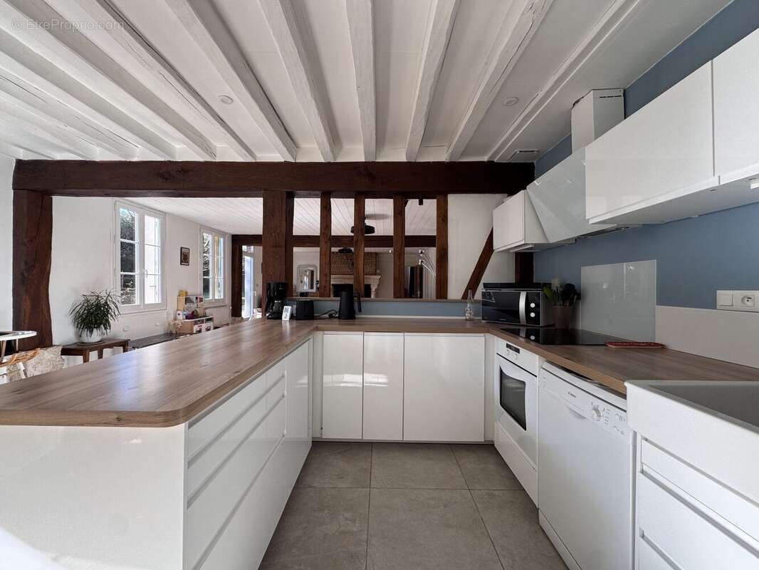 Cuisine ouverte équipée avec insert, moderne et fonctionnelle, intégrée à une grande pièce de vie lumineuse. - Maison à CRASVILLE