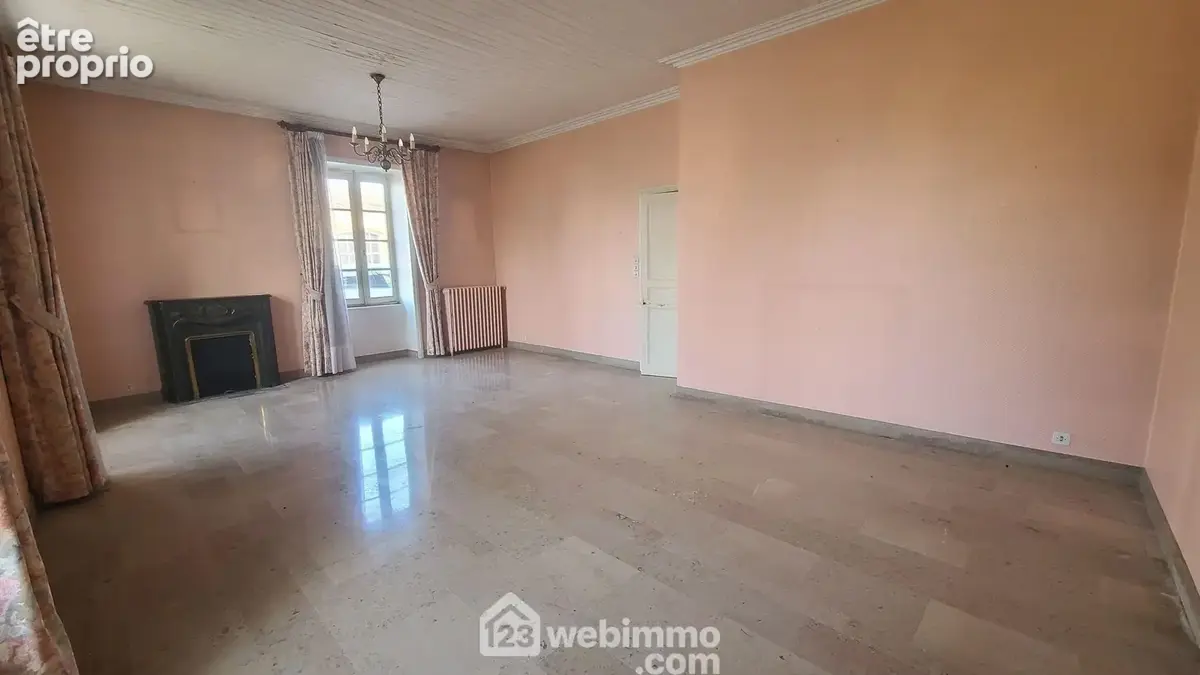 Séjour salon, belle hauteur sous plafond 2m70, cheminée et travertin au sol.
