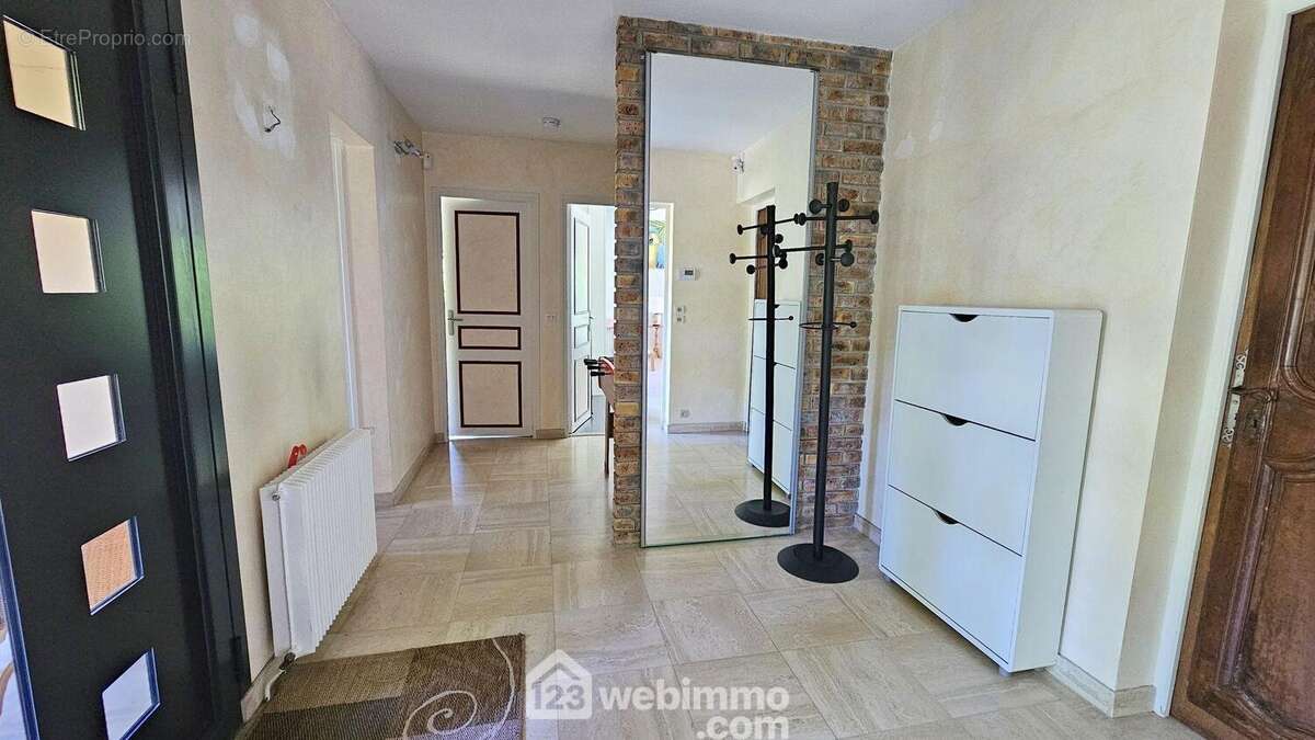 Une entrée spacieuse de 12 m² avec ses placards. - Maison à BARBIZON