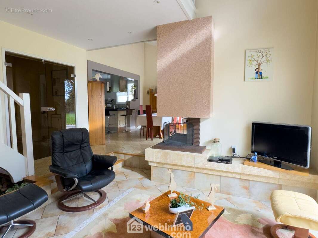 ...avec une cheminée ouverte sur le coin salon. - Maison à CHOLET