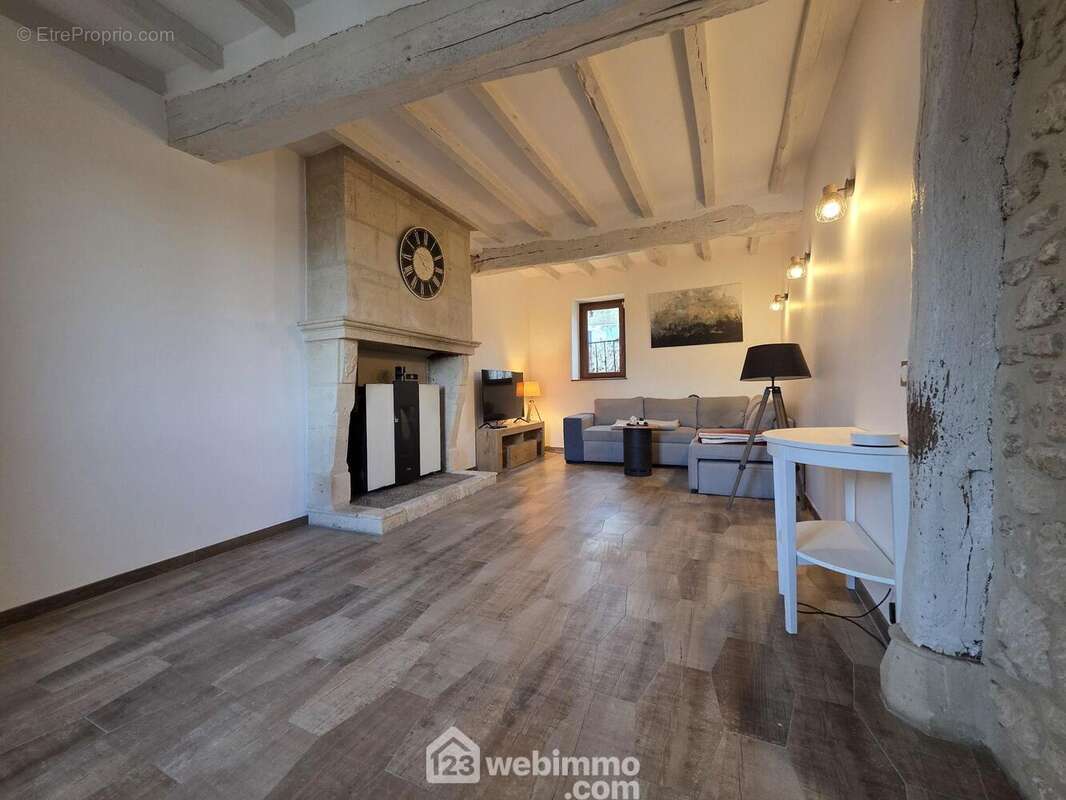 Belle pièce de vie spacieuse et lumineuse, sublimée par des poutres apparentes et offrant un volume de 22m² pour un confort de vie au quotidien. - Maison à REVILLON
