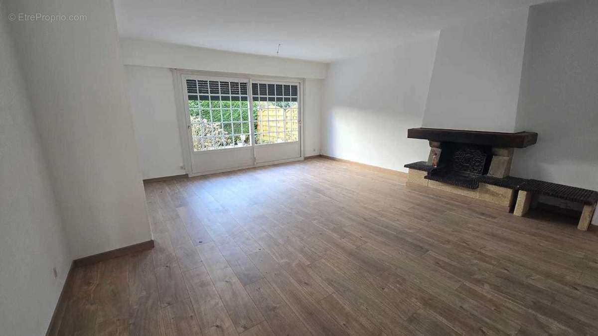 Grand salon / salle à manger, cheminée, très lumineux, donnant sur le jardin.