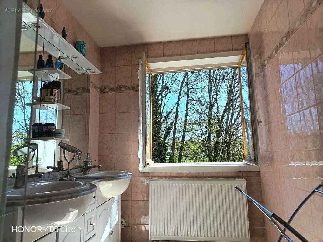 Une salle de bain avec une grande fenêtre pour faciliter l'aération de  la pièce humide.
 - Maison à LANDSER