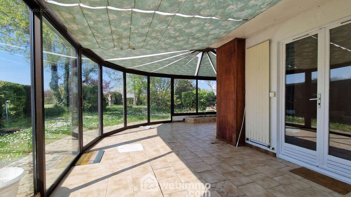 Accessible depuis le séjour, une véranda lumineuse de 30 m² donnant sur le jardin - Maison à CHAMBRY