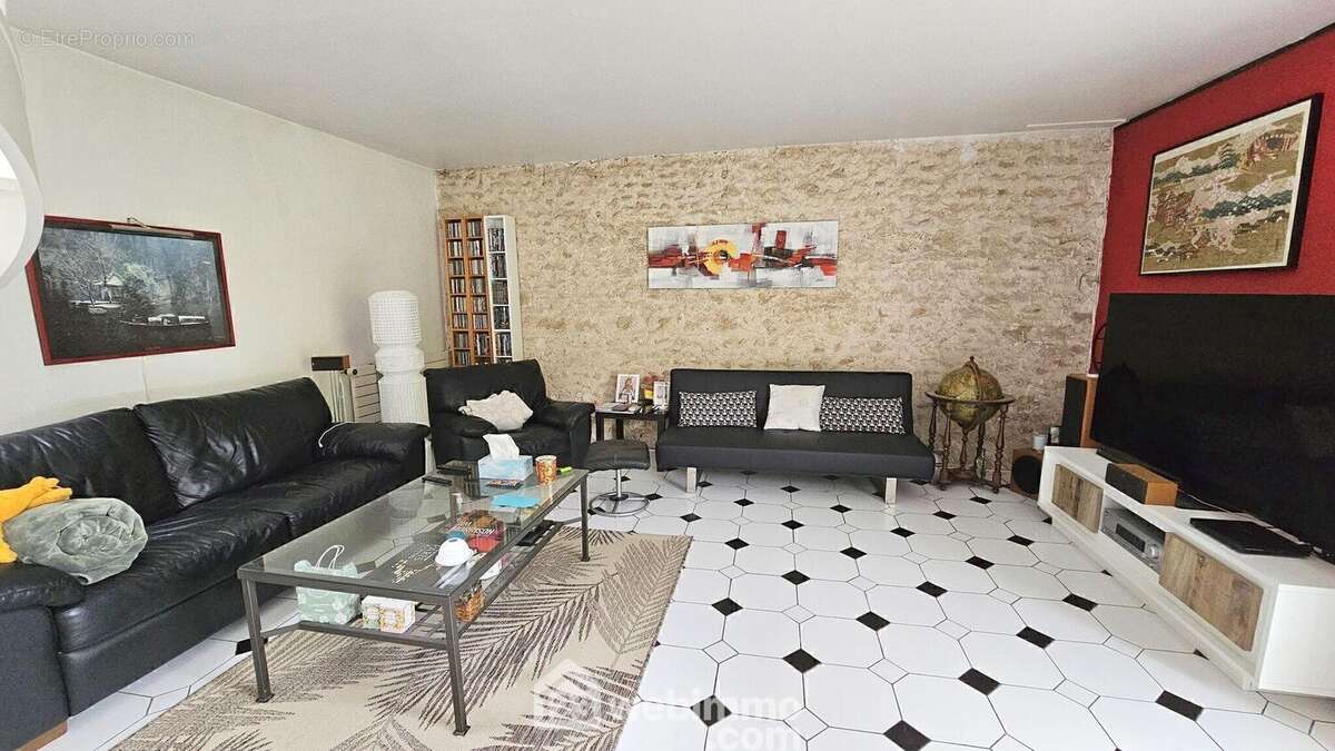 Voici le séjour avec ses pierres apparentes..