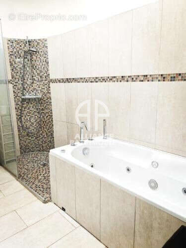 Salle bains avec balnéo et douche - Appartement à PARIS-16E