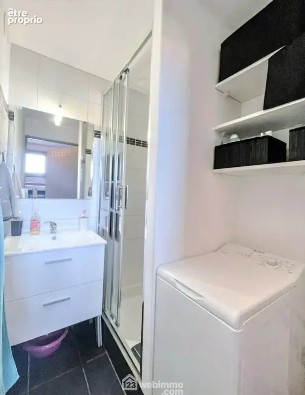 Salle d'eau fonctionnelle avec rangements.