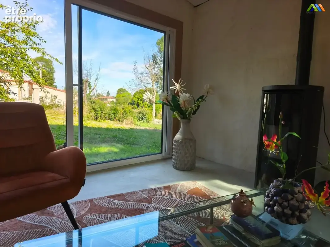 Belle vue sur le jardin depuis le séjour, avec de grandes ouvertures sur l'extérieur