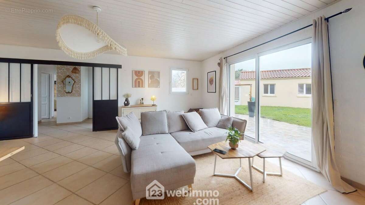 Sans vis-a-vis et ouvert sur le jardin en façade, le salon est même un jour pluvieux particulièrement lumineux. - Maison à SAINT-VINCENT-SUR-JARD