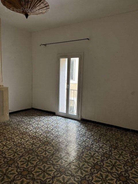 Le salon-séjour avec sa porte fenêtre et son balcon - Appartement à SETE