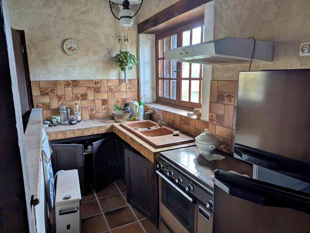 cuisine ouverte sur la pièce à vivre avec cheminée - Maison à SEMENTRON