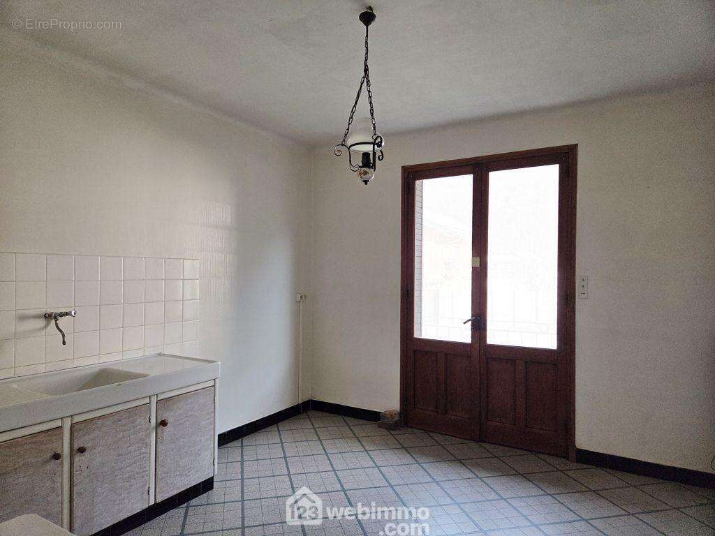 Au rez-de-chaussée surélevé, on retrouve une cuisine indépendante avec placard donnant accès à un balcon exposé Est, - Maison à LA BATHIE