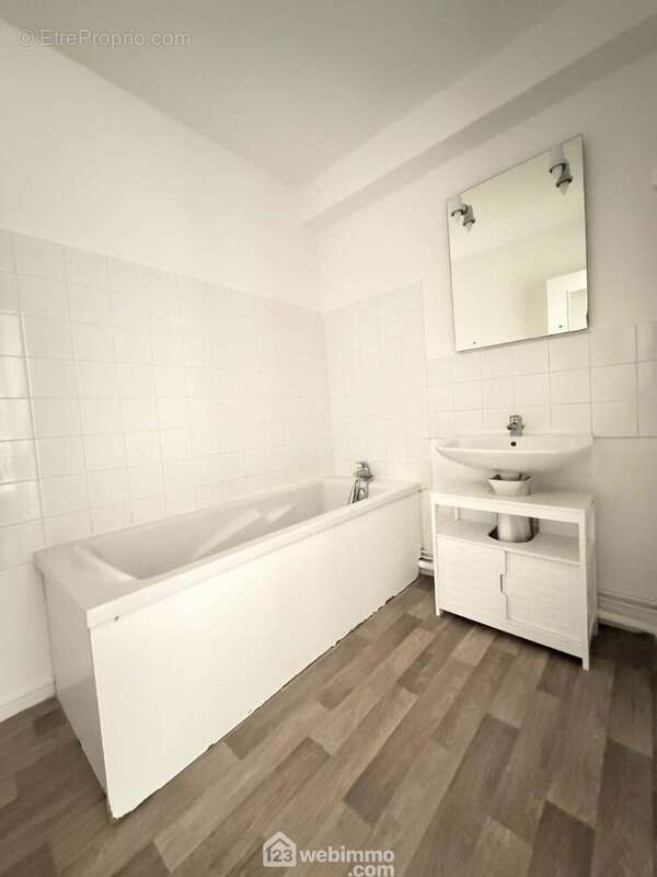 La salle de bains avec lavabo et baignoire - Appartement à LAON