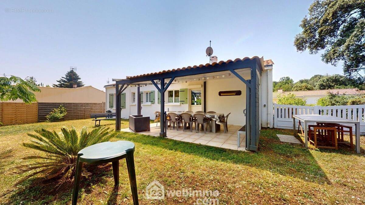 Façade avec terrasse carrelée sous pergola - Maison à SAINT-VINCENT-SUR-JARD