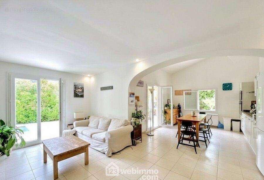 Belle pièce de vie baignée de lumière grâce aux larges ouvertures sur les terrasses et le jardin. - Maison à SAINTE-MAXIME