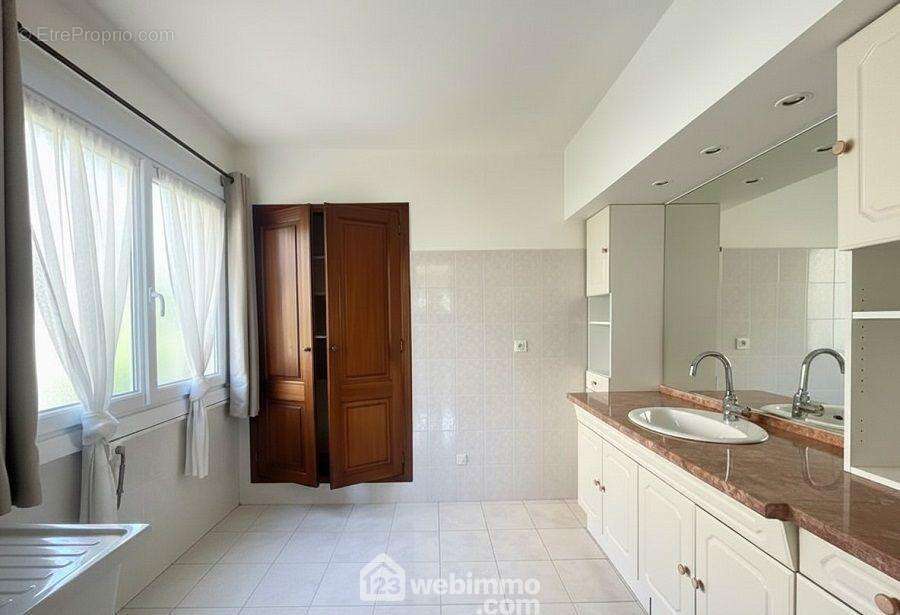 Salle de bains spacieuse avec fenêtre apportant lumière naturelle et ventilation. - Appartement à FREJUS