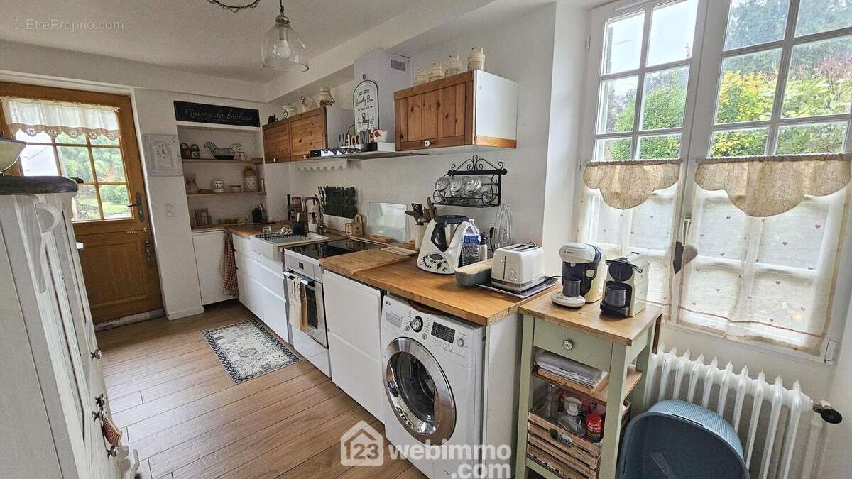 Une cuisine fonctionnelle avec un accès sur la terrasse. - Maison à GIRONVILLE-SUR-ESSONNE