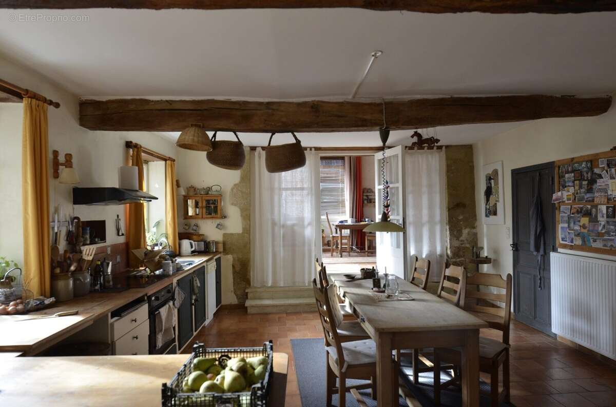 Traditional kitchen and dining room with exposed beams and warm country-house character. - Maison à BASSOUES