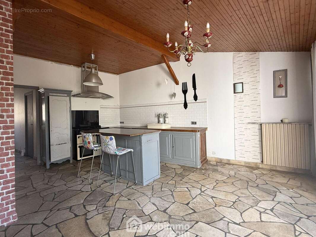 Au-delà, une cuisine - salle à manger de 19 m2. - Maison à NEUVILLE-DE-POITOU