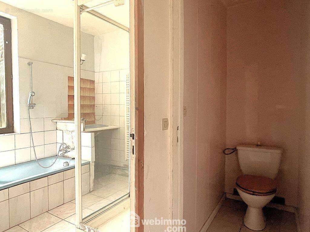 D'un côté, un couloir dessert la buanderie, la salle de bain et le WC. - Maison à NUEIL-SOUS-FAYE