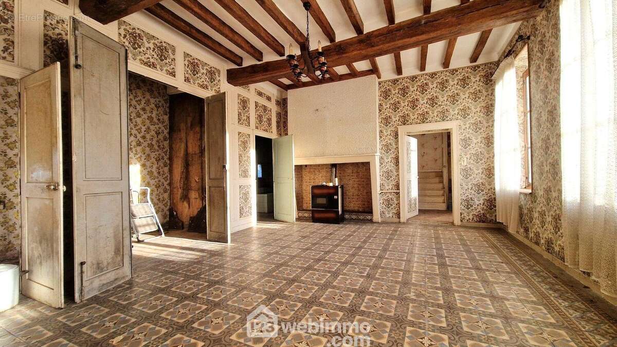 Il est lumineux et bénéficie d'une cheminée - Maison à MONTAIGU