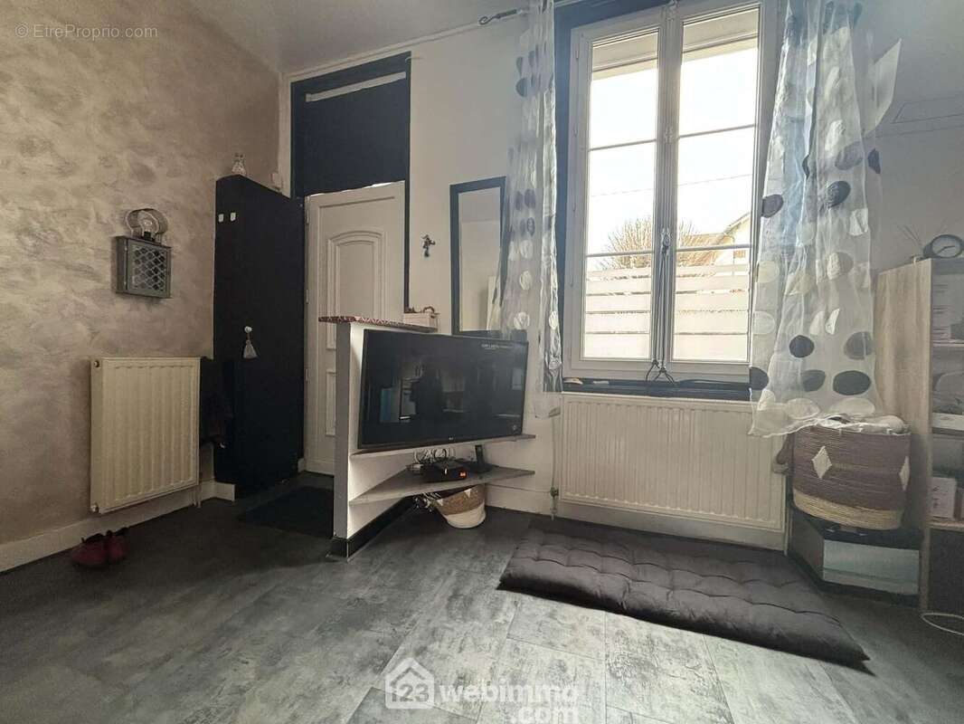 Au-delà de l'entrée, la pièce de vie de 32 m2 : - Maison à CHATELLERAULT