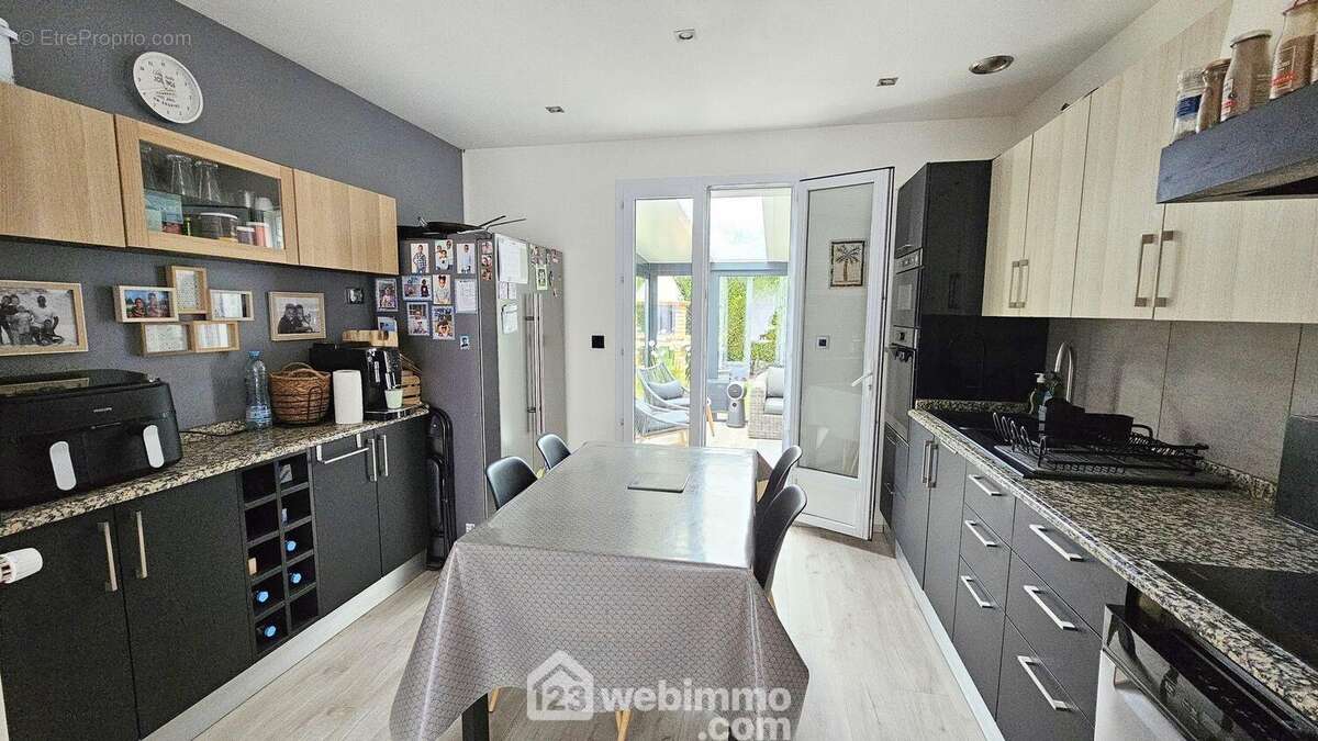 Une cuisine avec un accès sur la véranda... - Maison à MILLY-LA-FORET