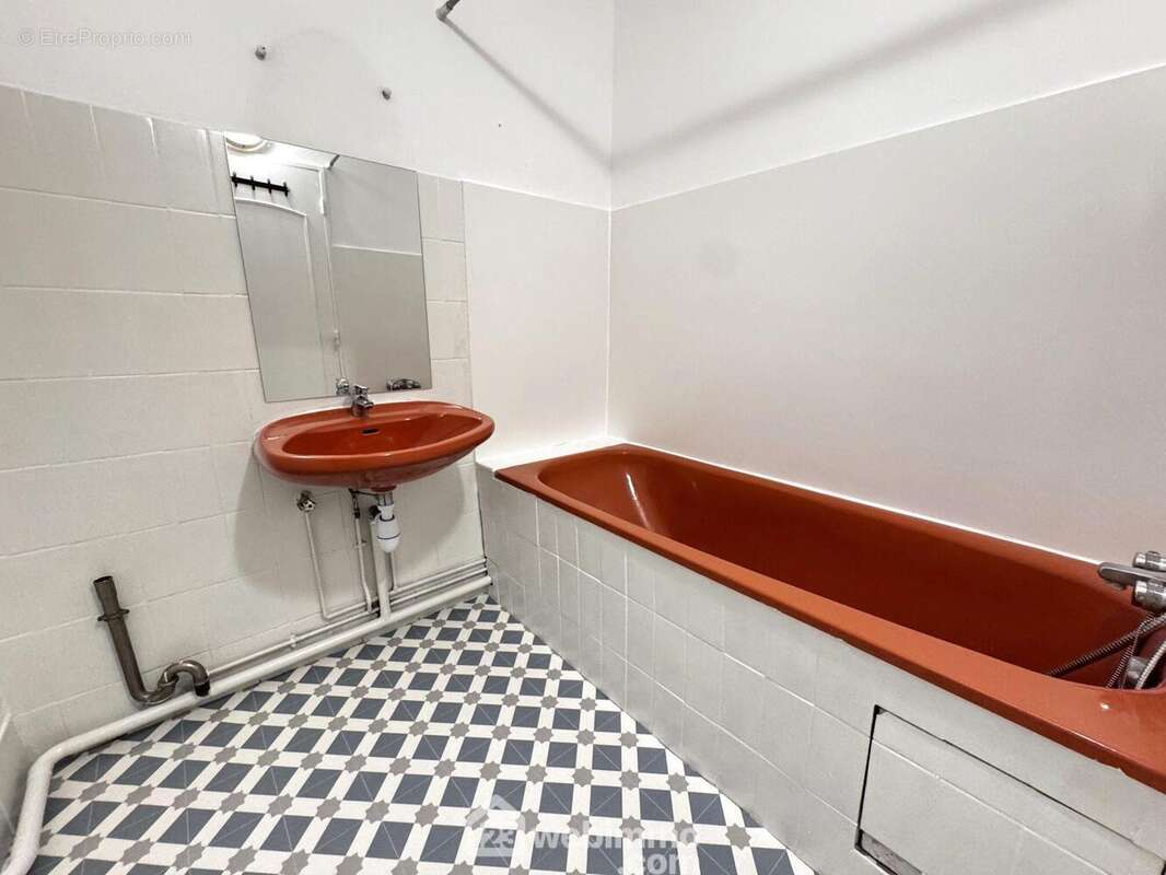 Terminons par la salle de bains, équipée d?une baignoire et d?un meuble vasque.