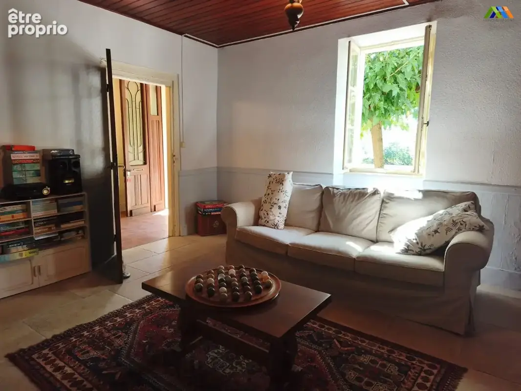 Salon accueillant avec vue sur le jardin, mobilier traditionnel et atmosphère agréable.