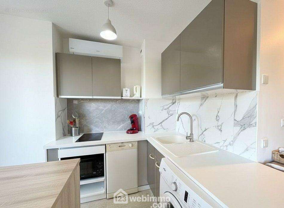 Cuisine ouverte équipée optimisant chaque mètre carré pour un quotidien pratique. - Appartement à SAINTE-MAXIME