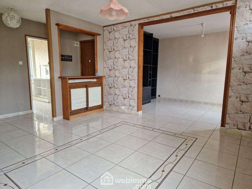 Sa pièce de vie lumineuse de 33m² est séparée en deux espaces. - Appartement à ALBERTVILLE