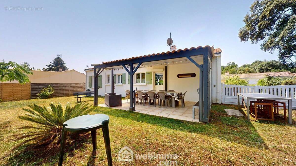Façade avec terrasse carrelée sous pergola - Maison à SAINT-VINCENT-SUR-JARD