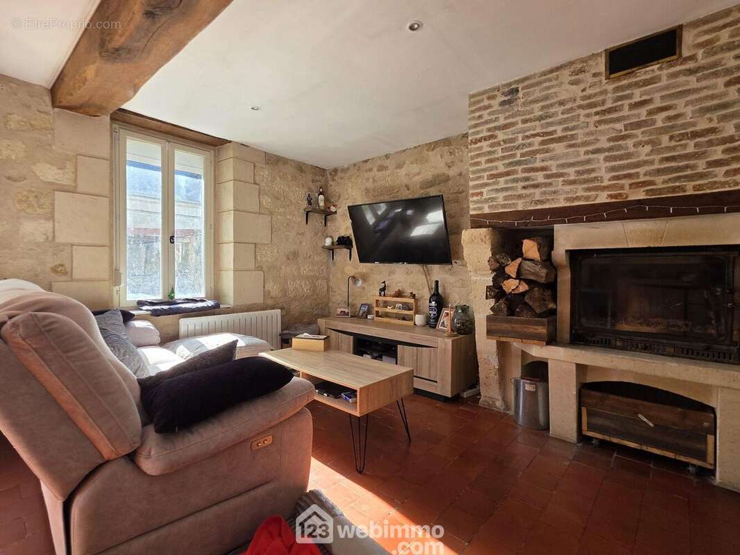 Un salon à l'atmosphère chaleureuse, où le cachet préservé des matériaux anciens crée une ambiance particulièrement accueillante - Maison à BOURGUIGNON-SOUS-MONTBAVIN