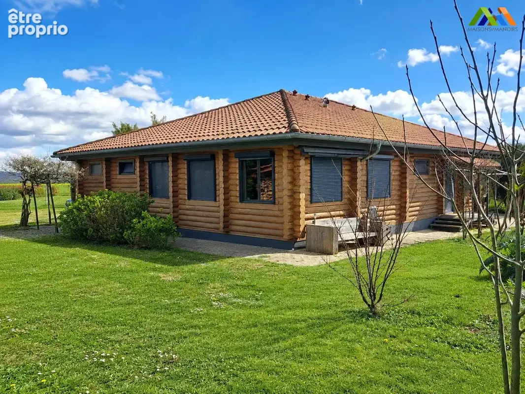 Wooden chalet exterior with garden, lawn and surrounding greenery.