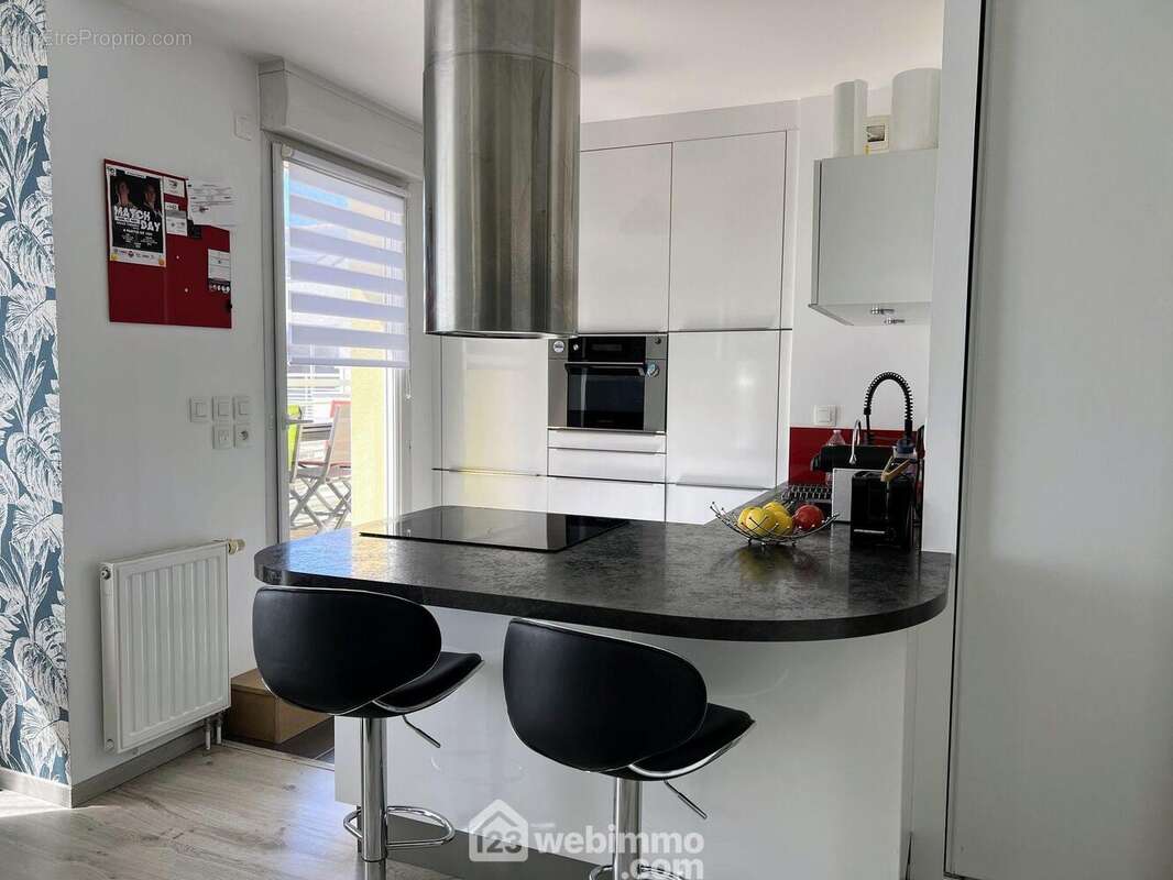 Une cuisine entièrement aménagée et équipée complète la pièce de vie. - Appartement à AVRILLE