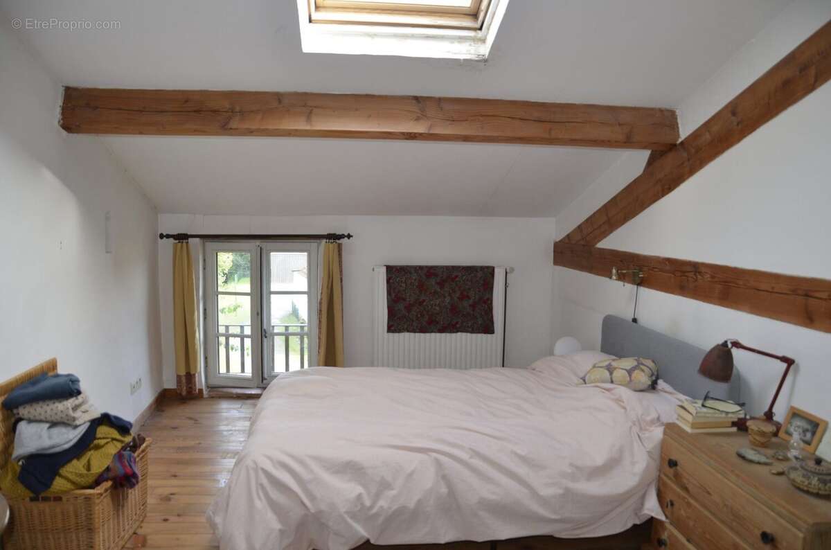 Bright bedroom with exposed beams, wooden floor and traditional character in a village house. - Maison à BASSOUES