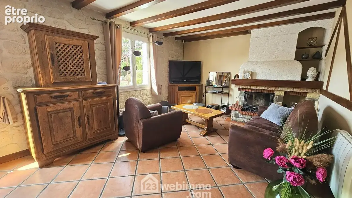 Un séjour lumineux avec sa cheminée insert.
