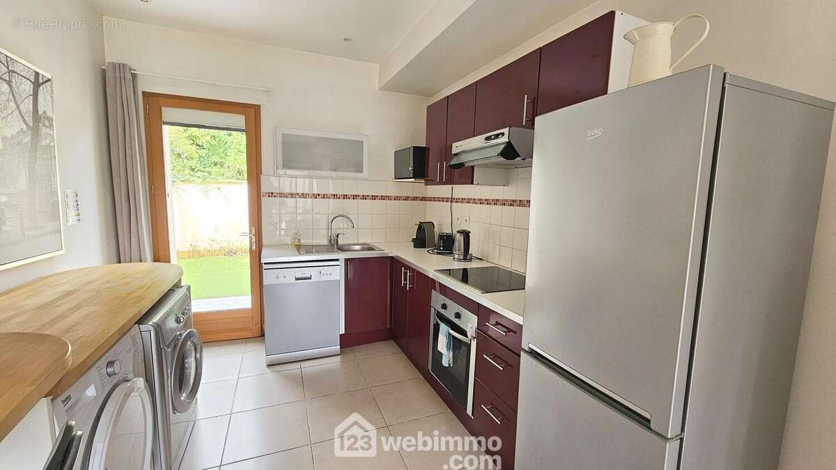 Une cuisine avec un accès sur une seconde terrasse de 32 m². - Maison à ARBONNE-LA-FORET