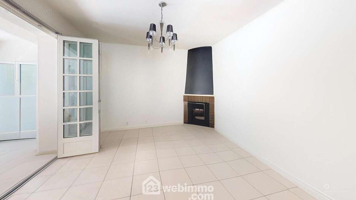 Salon avec cheminée ouverte et patio donnant sur le jardin - Maison à JARD-SUR-MER
