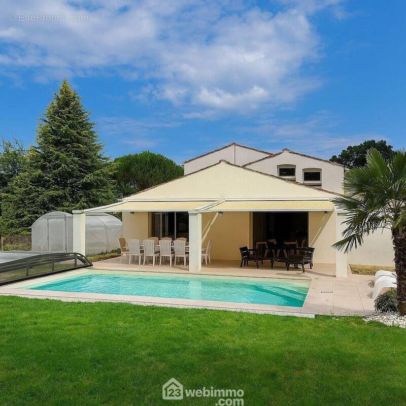 Grand jardin paysager offrant un cadre verdoyant avec vue dégagée, piscine couverte et terrasse pour profiter pleinement de l&#039;extérieur. - Maison à POIROUX